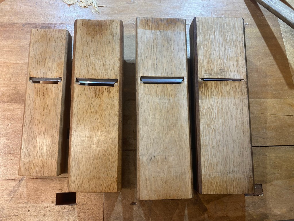 Bottom view of four Japanese planes showing progressively tighter mouth openings, three refurbished used kanna and one new plane