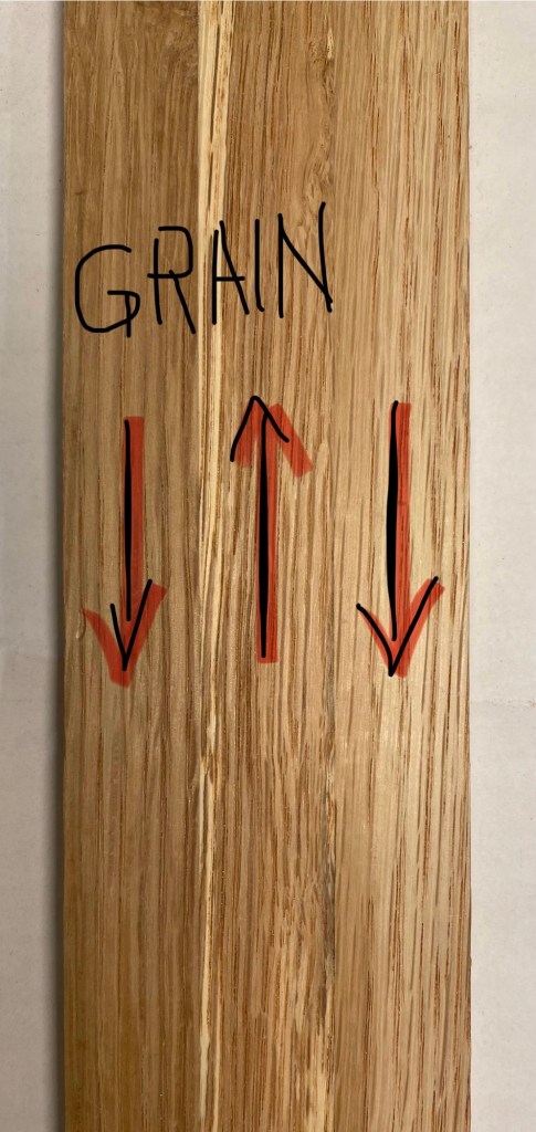 Three laminated oak boards with conflicting grain direction creating planing challenges for trestle table base